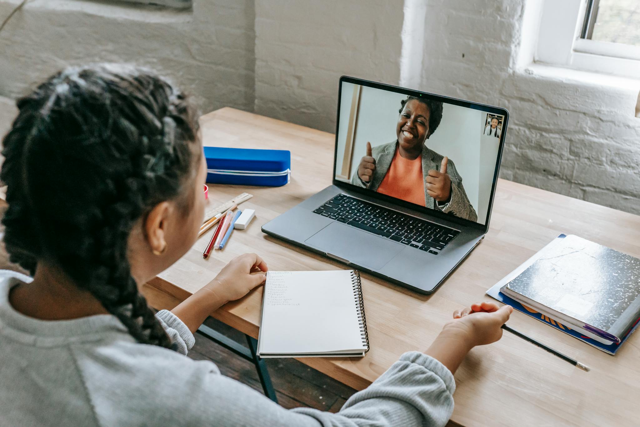 A young student connecting with a teacher via video call for an online lesson.