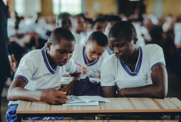 African students concentrating on their studies in a classroom setting, wearing uniforms.