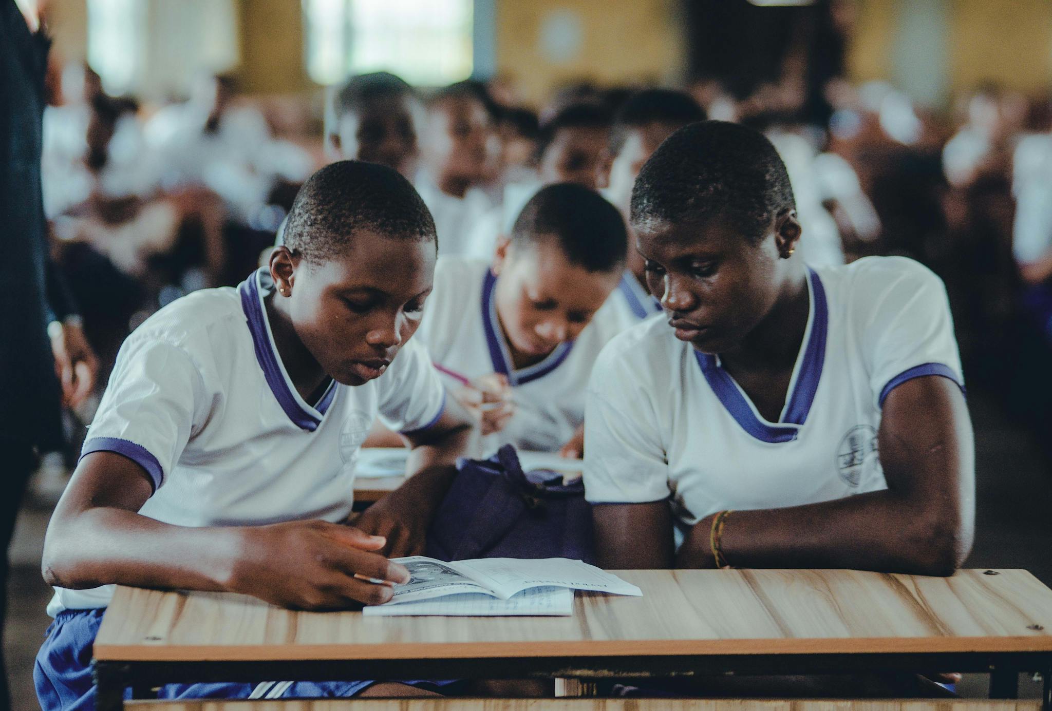 African students concentrating on their studies in a classroom setting, wearing uniforms.